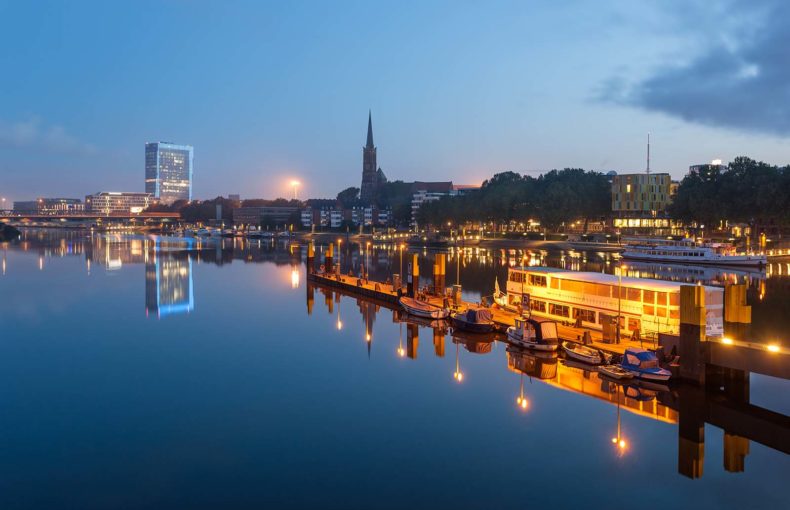 Reflection of Bremen skyline in the calm waters of river Weser, in Bremen Germany.