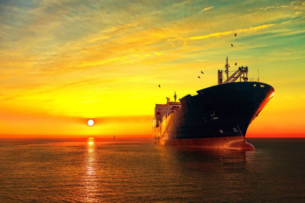 Oil tanker ship at sea on a background of sunset sky