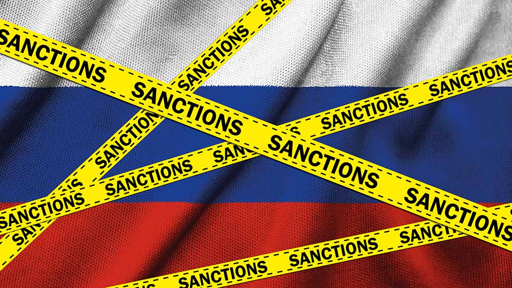Yellow Tape with Sanctions Sign against the national flag of Russia on fabric texture background