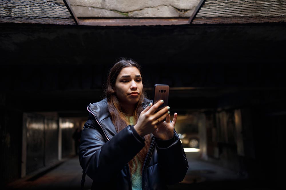 Young woman reading about news in the underground shelter