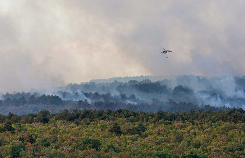 Helicopter against wildfire during strong wind and drought
