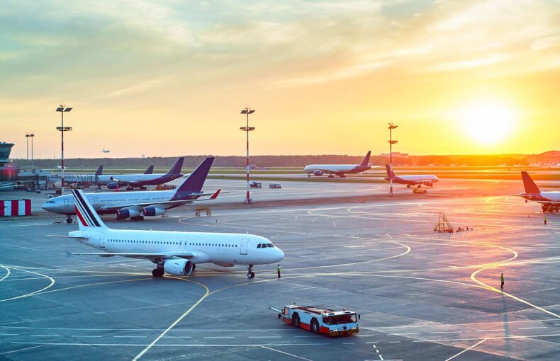 Airport with grounded airplanes at sunset