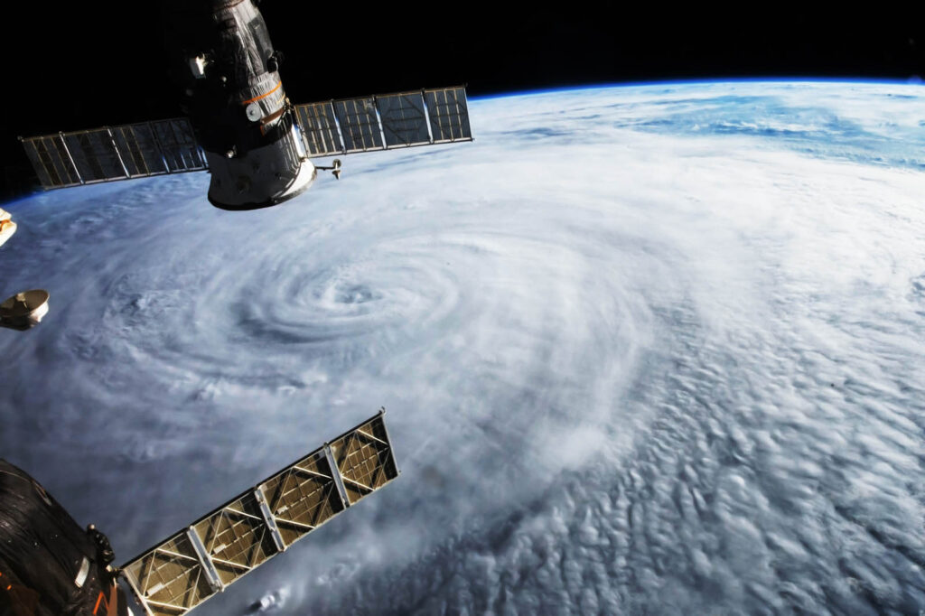 A view from space of a hurricane with two satellites observing from above