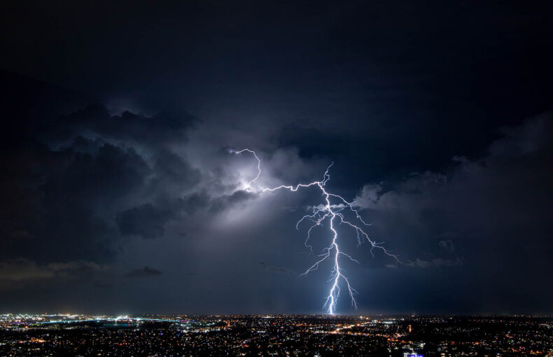Lightning strike over city lights